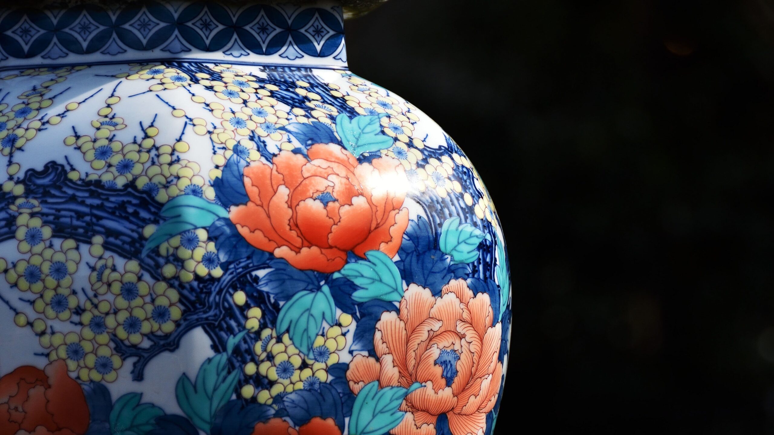 牡丹と草花の絵付けが施された華やかな陶磁器の花瓶